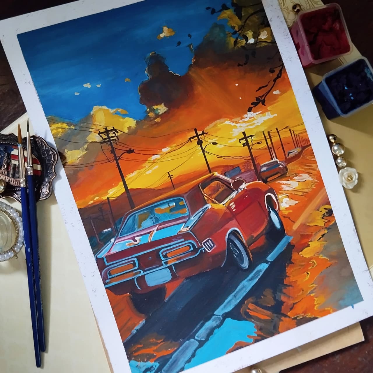 Painting of classic cars on a sunset road